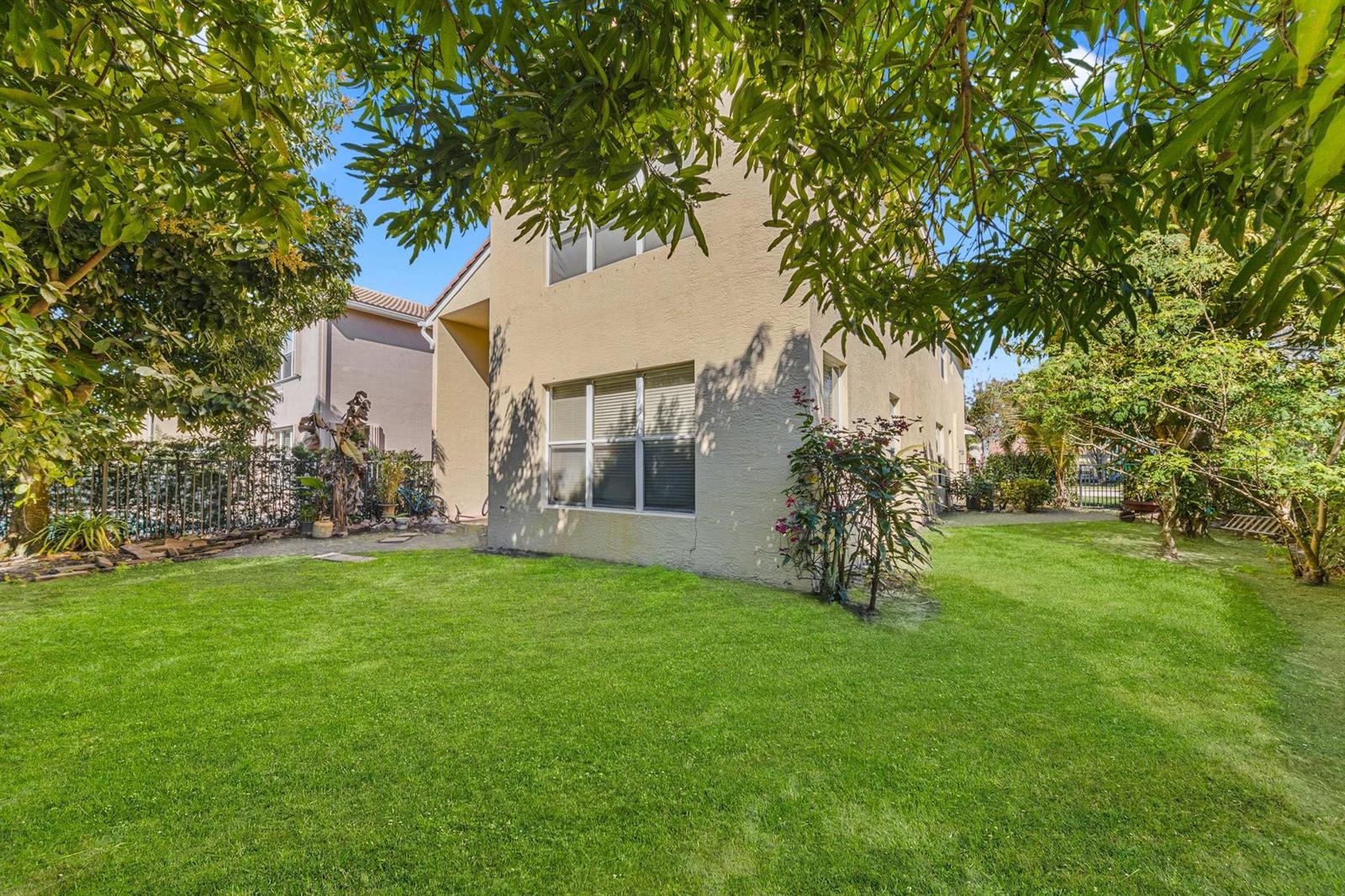 A two-story stucco house exterior with a large green lawn and surrounding trees — 11729 Rock Lake Terrace, Boynton Beach FL 33473, BOYNTON BEACH, FL