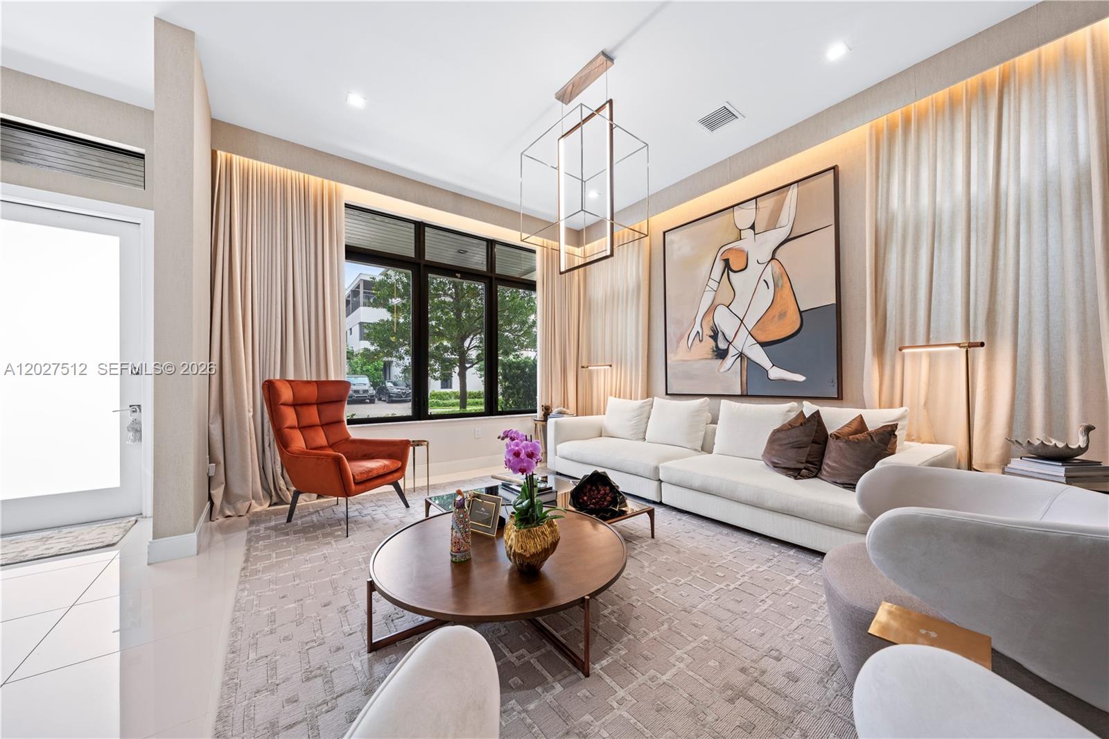 A modern living room features a white sofa, orange armchair, and large abstract wall art — 8162 NW 48th Ter, Doral FL 33166, DORAL, FL