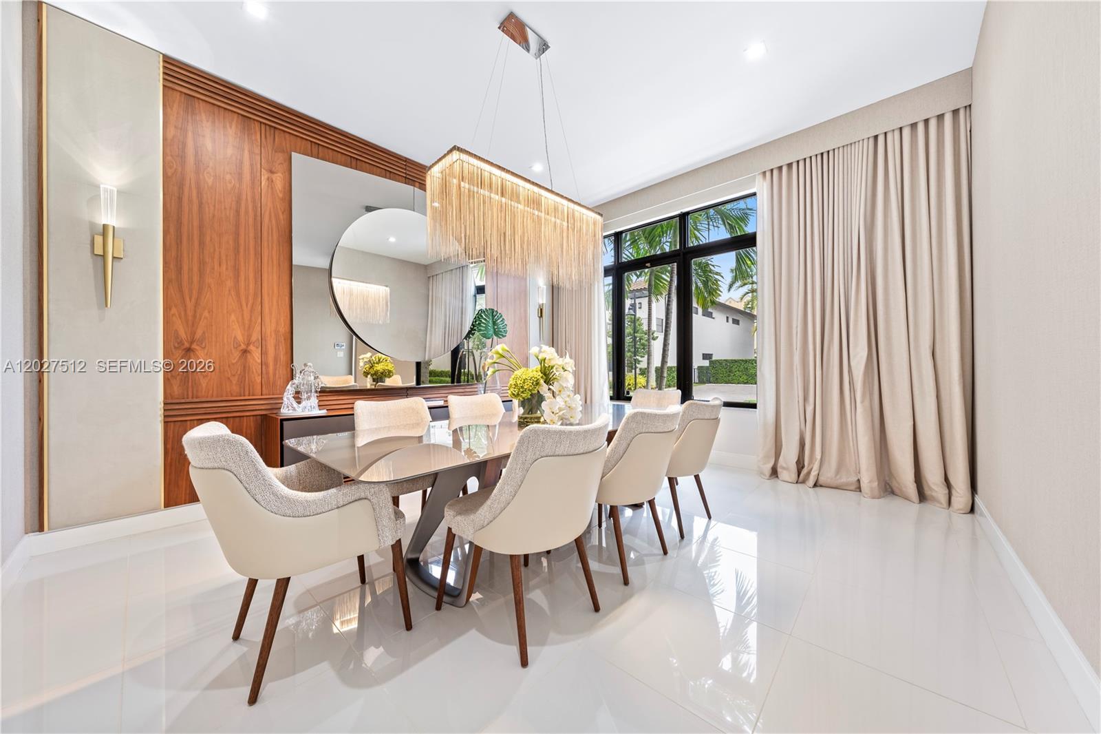 A modern dining room features a glass table, upholstered chairs, and a gold fringe chandelier — 8162 NW 48th Ter, Doral FL 33166, DORAL, FL