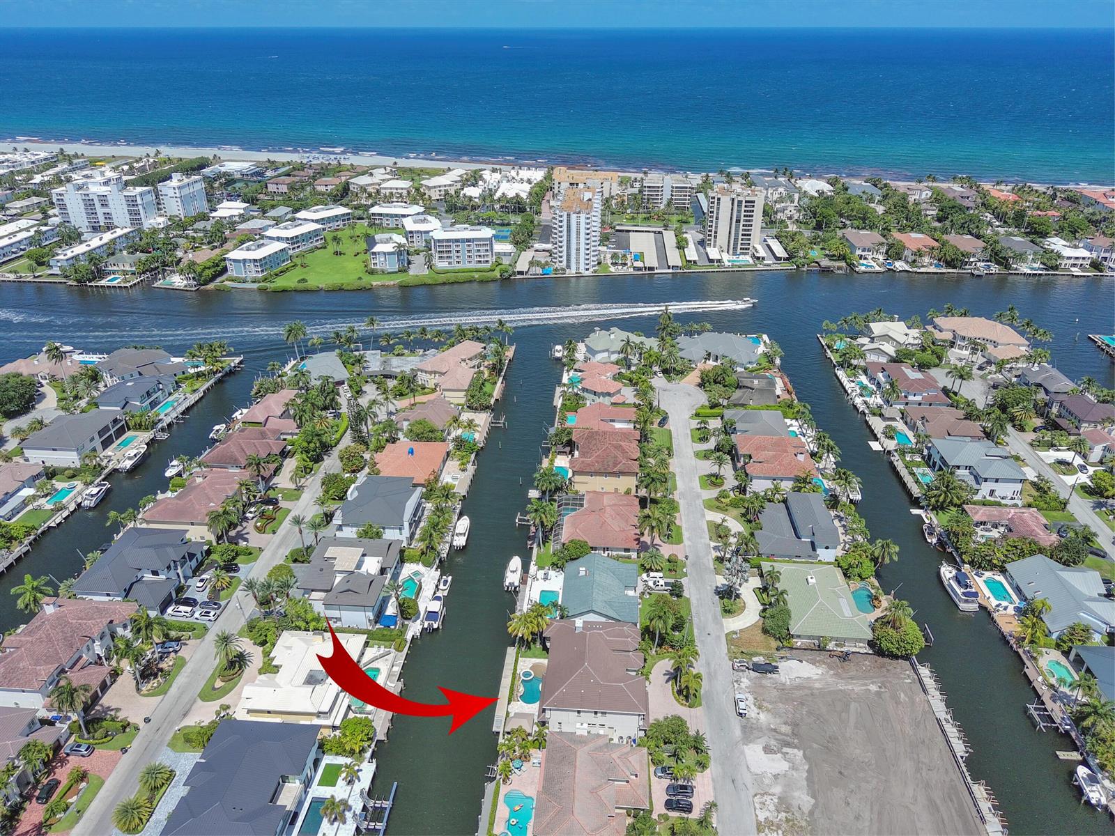 An aerial view shows waterfront homes with private docks and pools along a canal — 945 Cypress Drive, Delray Beach FL 33483, DELRAY BEACH, FL