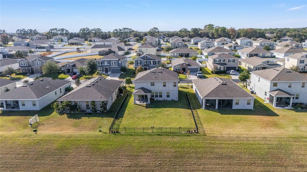 An aerial view shows a residential neighborhood with houses featuring fenced backyards and roofs — 5655 SW 50TH AVENUE, OCALA, FL