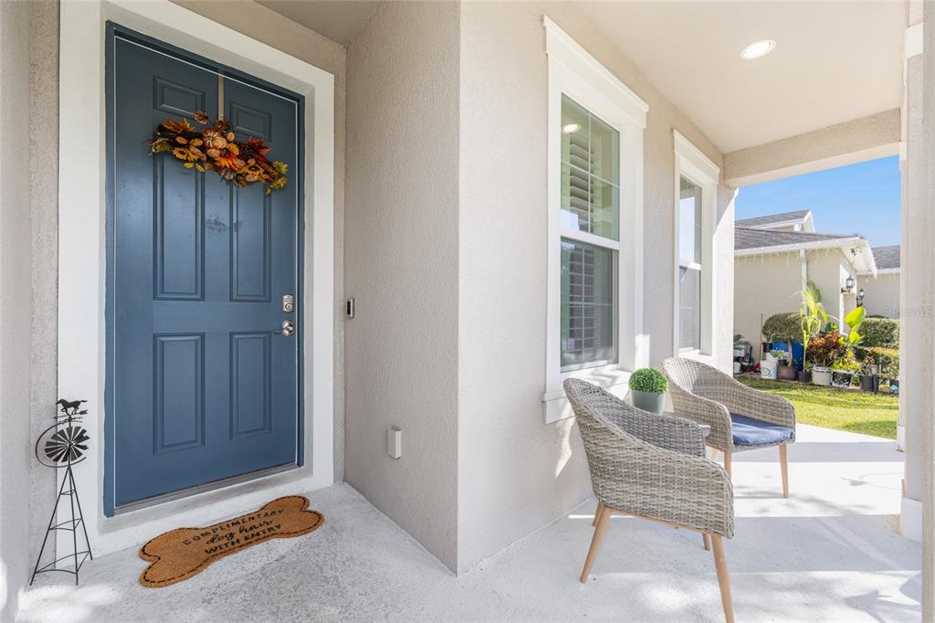 A front porch features a blue door, two wicker chairs, and a bone-shaped doormat — 5655 SW 50TH AVENUE, OCALA, FL