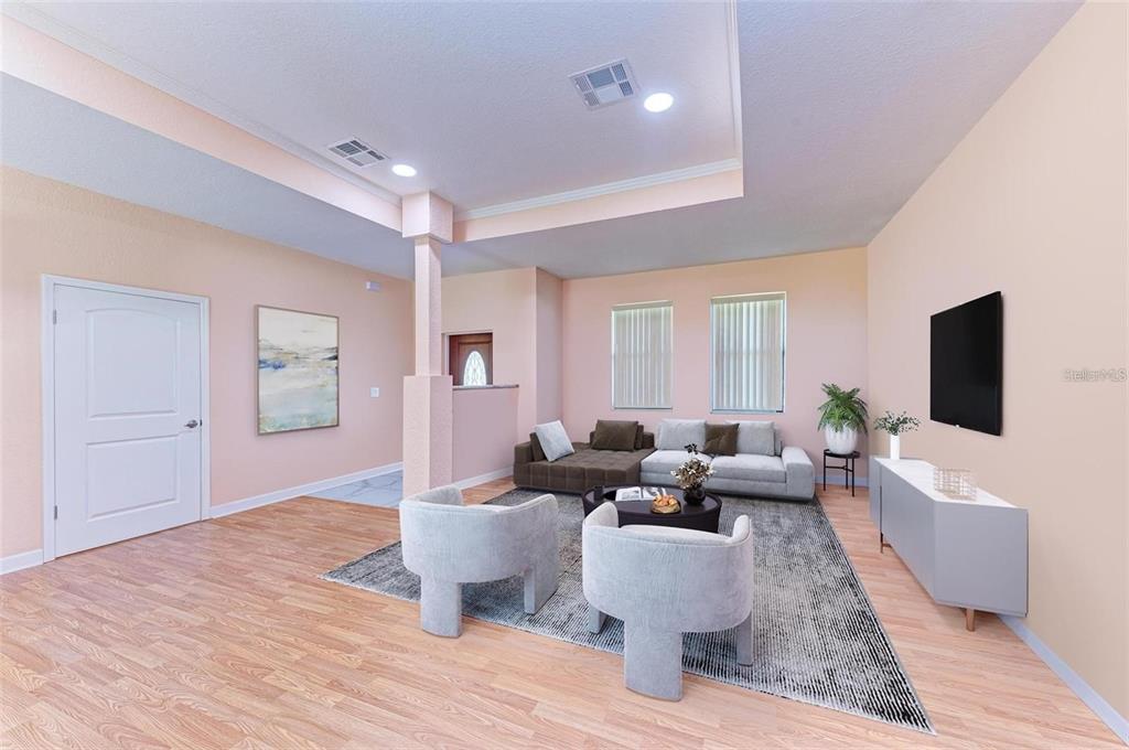 A living room with light wood flooring, a sectional sofa, two armchairs, and a television — 397 DONIPHAN DRIVE, PORT CHARLOTTE, FL