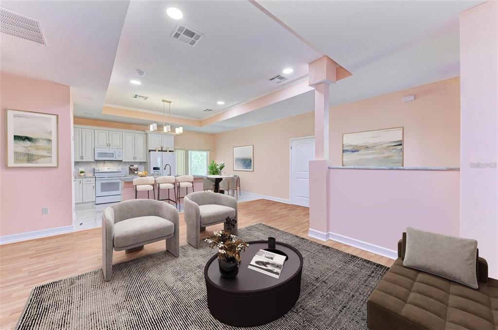 An open-concept living room and kitchen area with light pink walls and wood-look flooring — 397 DONIPHAN DRIVE, PORT CHARLOTTE, FL