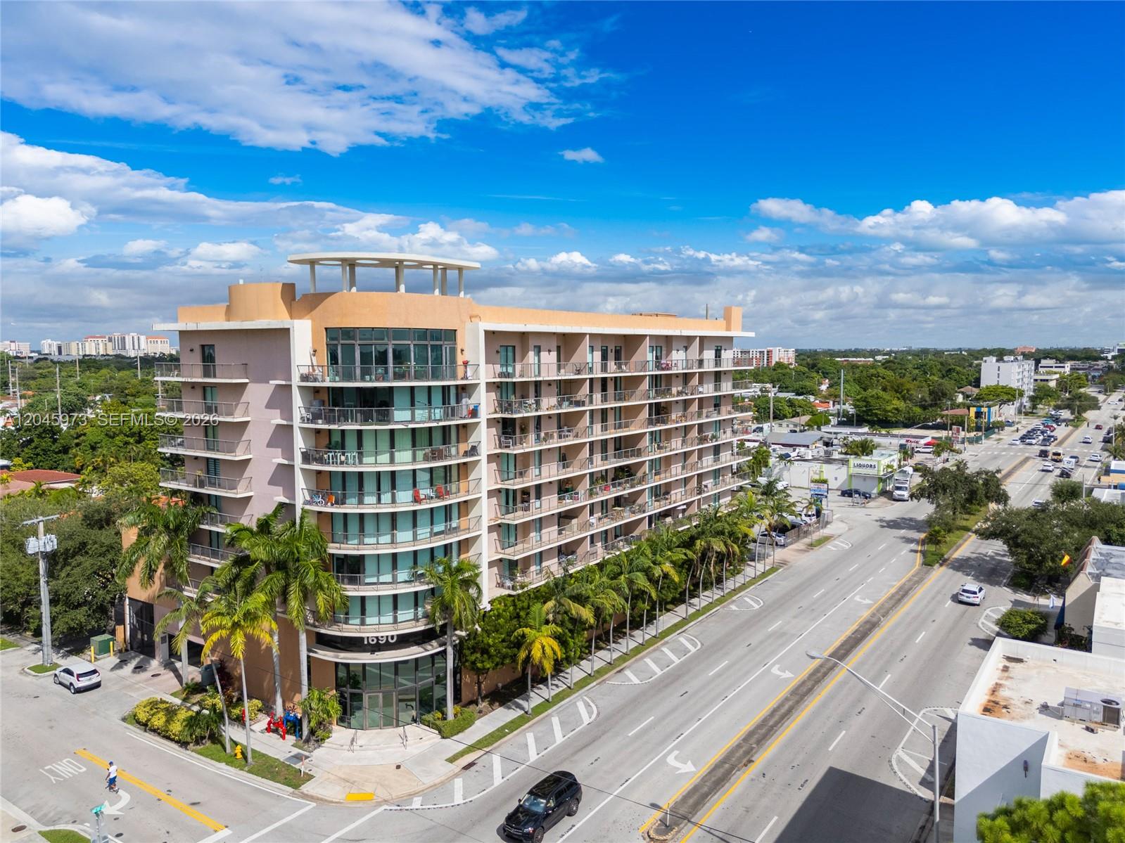 An aerial view shows a multi-story apartment building with balconies along a busy street — 1690 SW 27th Ave # 608, Miami FL 33145, MIAMI, FL