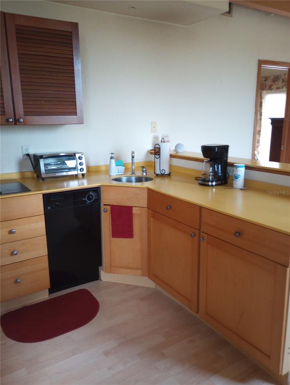 A kitchen features light wood cabinets, a yellow countertop, a black dishwasher, and a sink — 101 PALM HARBOR PARKWAY UNIT C226, PALM COAST, FL