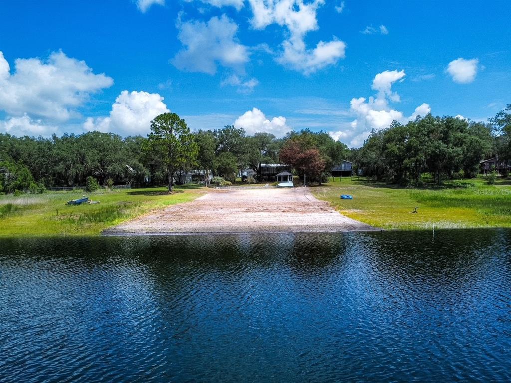 An aerial view of a sandy beach area leading to a lake with surrounding trees — 5616 SILVER SANDS CIRCLE, KEYSTONE HEIGHTS, FL