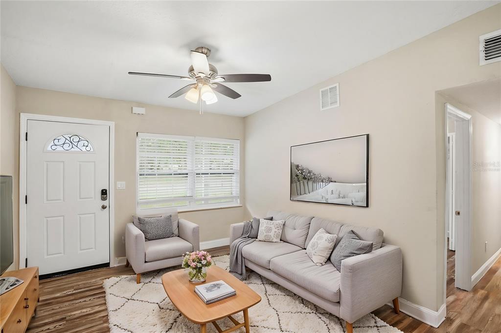 A living room features a sofa, armchair, coffee table, ceiling fan, and light wood flooring — 224 MURRY DRIVE, ORLANDO, FL