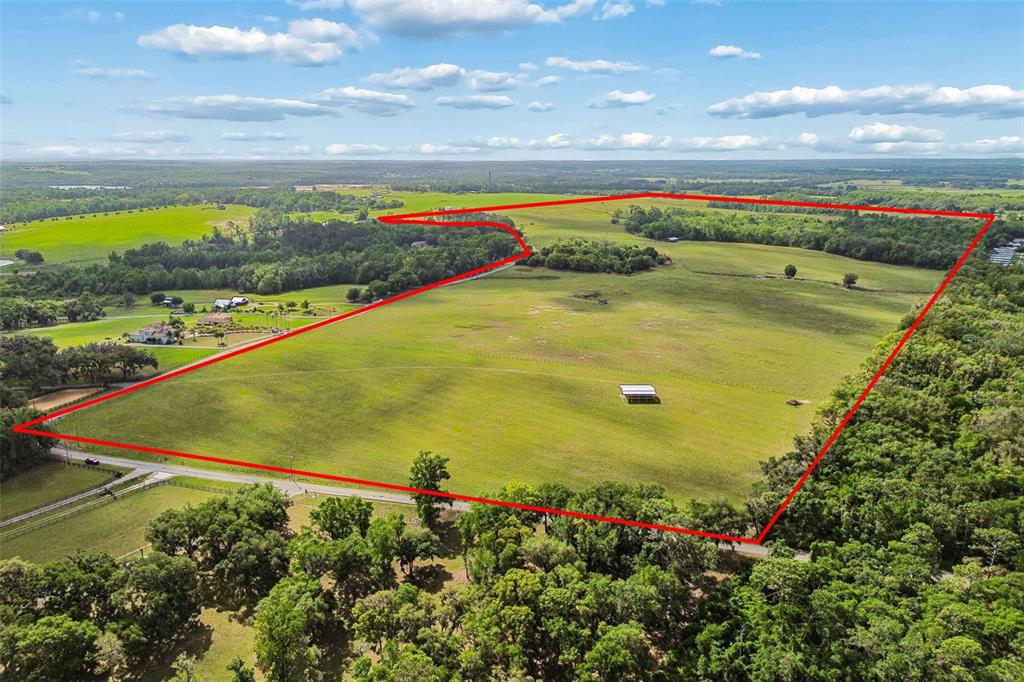 An aerial view shows a large, open grassy field outlined in red — BAYHEAD ROAD Lot 8, DADE CITY, FL