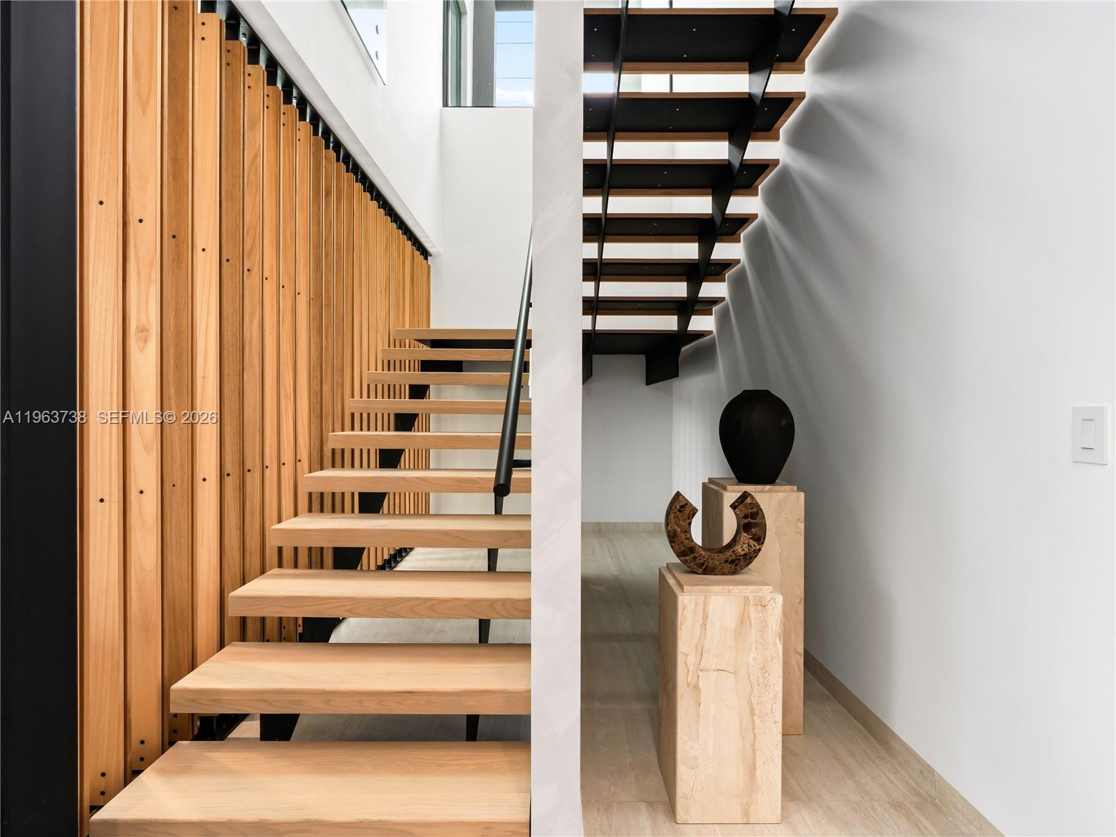 The exterior of a modern house features a gray garage, wood-slatted siding, and stone cladding — 4401 SW 14th St, Miami FL 33134, MIAMI, FL