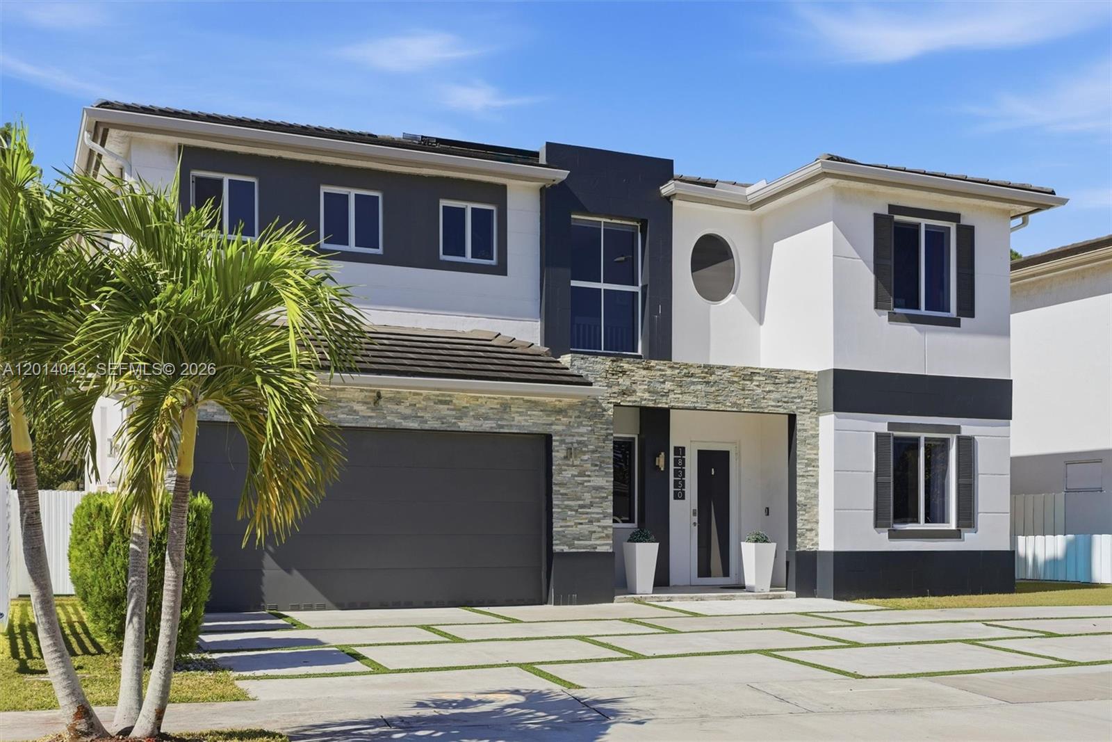 A two-story house with a stone-accented facade, a two-car garage, and a paved driveway — 18350 SW 139th Path, Miami FL 33177, MIAMI, FL