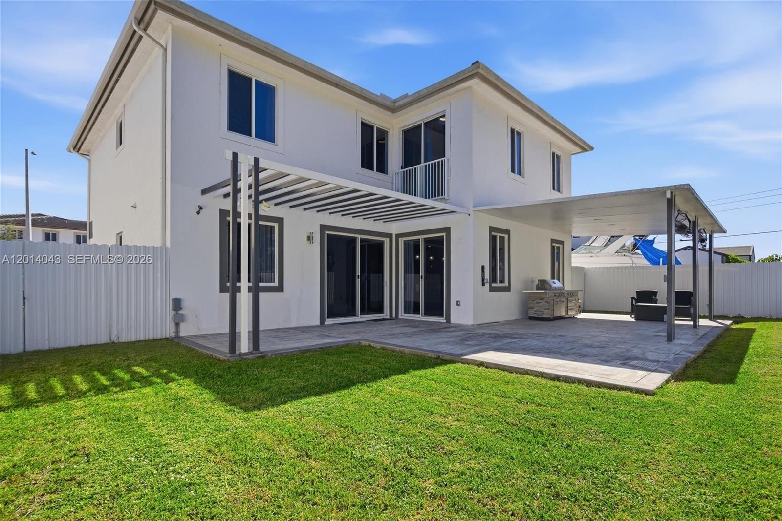 The backyard features a paved patio, a pergola, a covered seating area, and a grill — 18350 SW 139th Path, Miami FL 33177, MIAMI, FL
