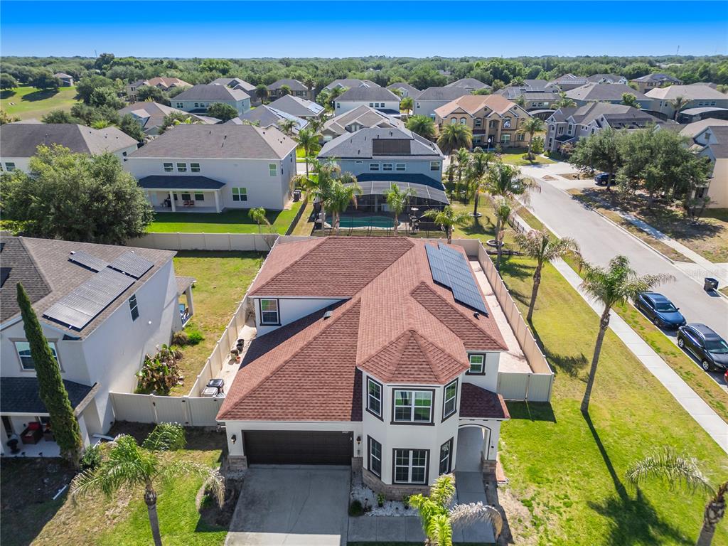 An aerial view shows a two-story suburban house with a red roof and solar panels — 2001 RED BLUFF AVENUE, APOPKA, FL