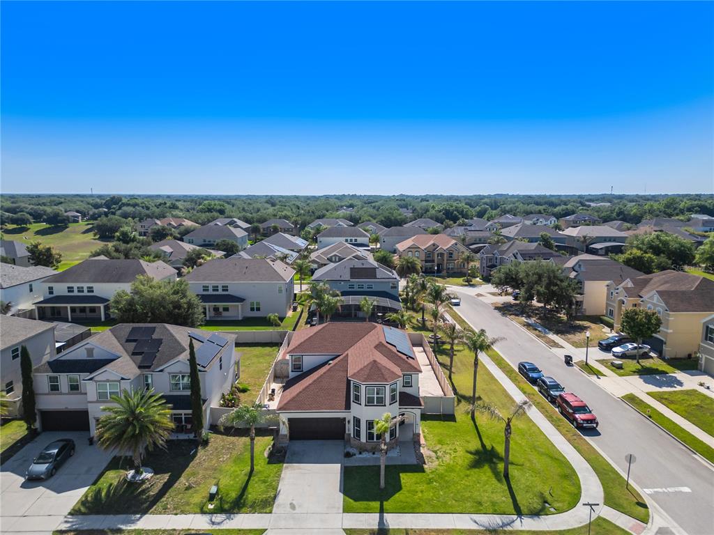An aerial view shows a suburban neighborhood with two-story houses, palm trees, and parked cars — 2001 RED BLUFF AVENUE, APOPKA, FL