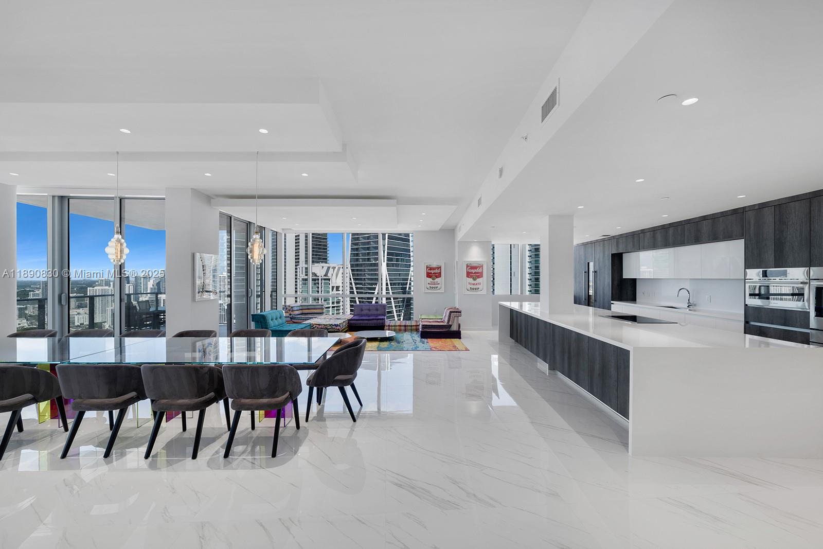 A modern open-concept kitchen and dining area features white marble floors and floor-to-ceiling windows — 851 NE 1st Ave, Miami FL 33132, MIAMI, FL