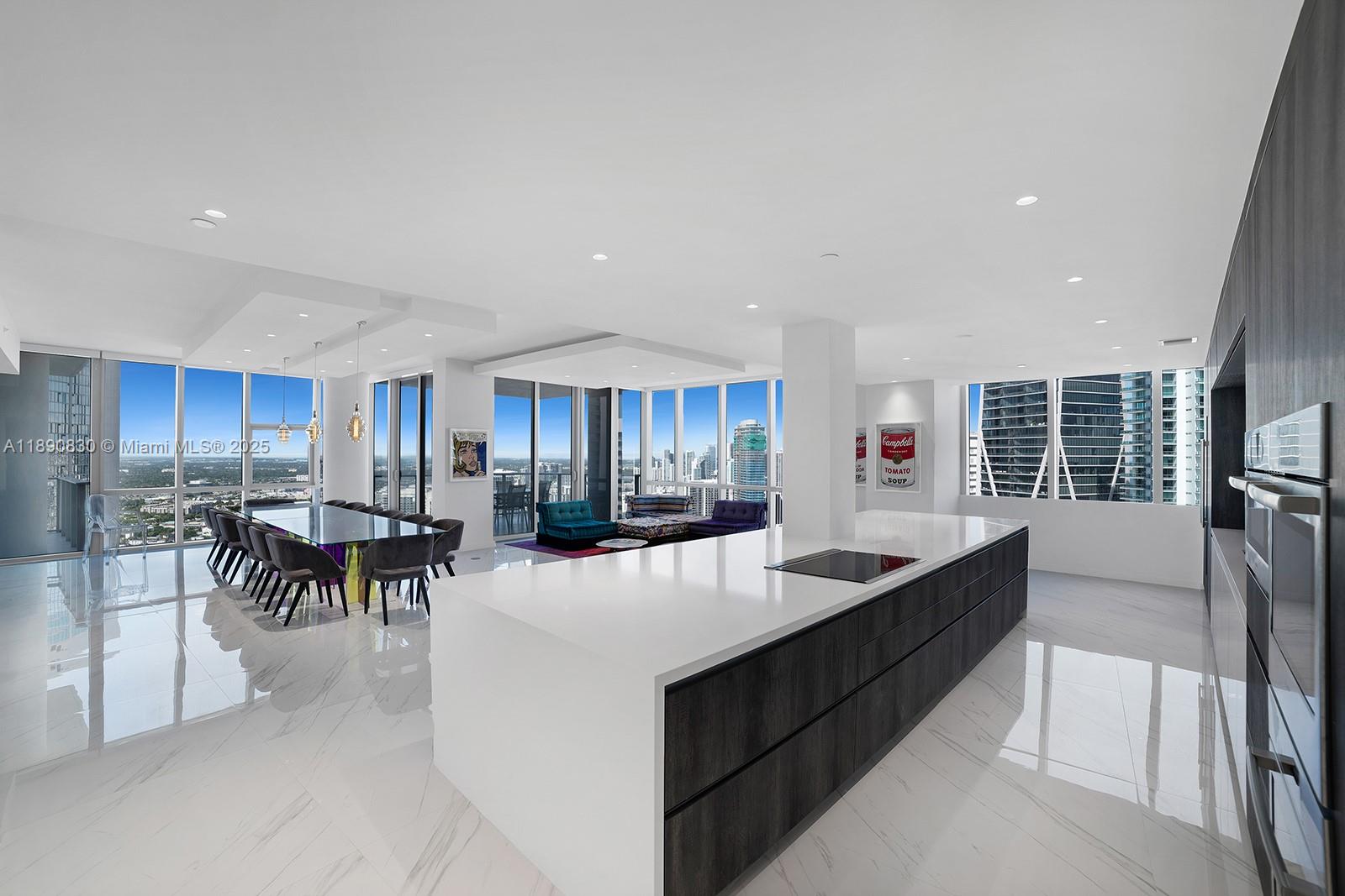 A modern open-concept kitchen and dining area features white marble floors and floor-to-ceiling windows — 851 NE 1st Ave, Miami FL 33132, MIAMI, FL