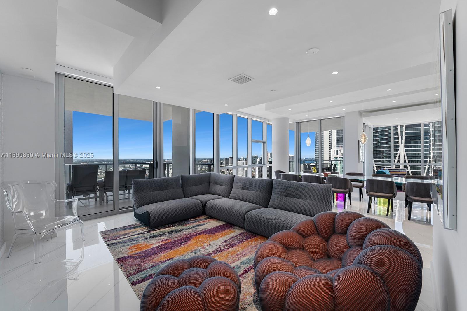 A modern living room features a grey sectional, textured chairs, and floor-to-ceiling windows with views — 851 NE 1st Ave, Miami FL 33132, MIAMI, FL
