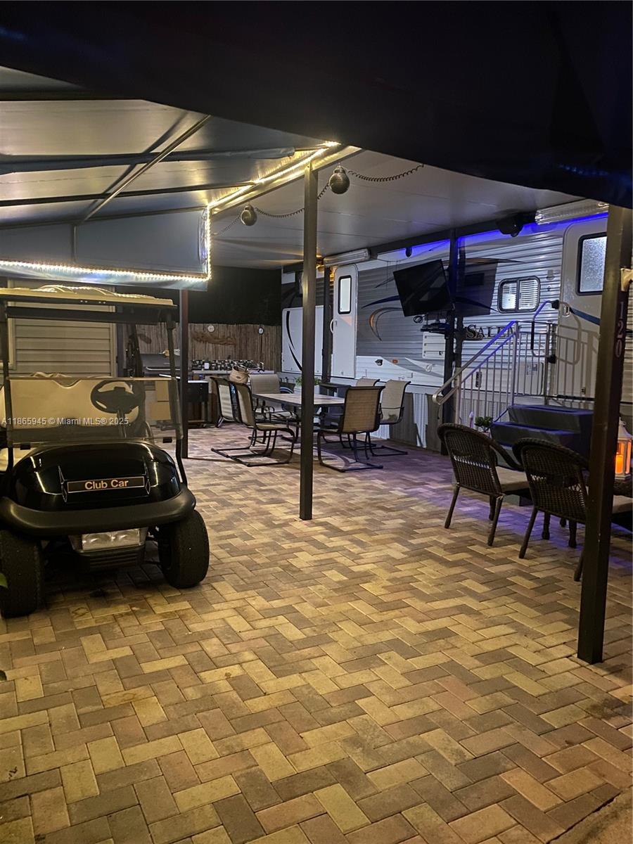 A paved outdoor patio features a golf cart, dining set, and a parked travel trailer — 325 Calusa St #120, Key Largo FL 33037, KEY LARGO, FL