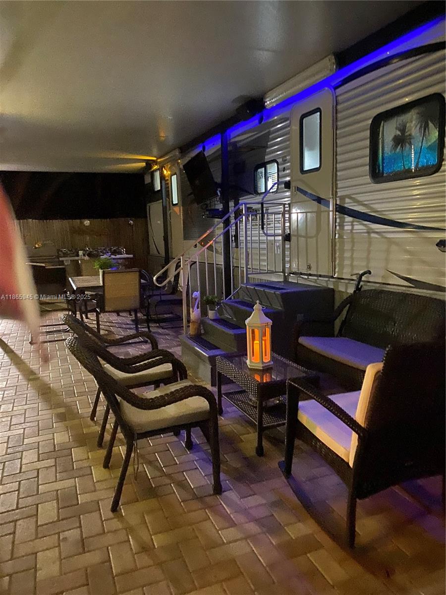 An outdoor patio area features a parked RV, wicker furniture, and a paved floor — 325 Calusa St #120, Key Largo FL 33037, KEY LARGO, FL