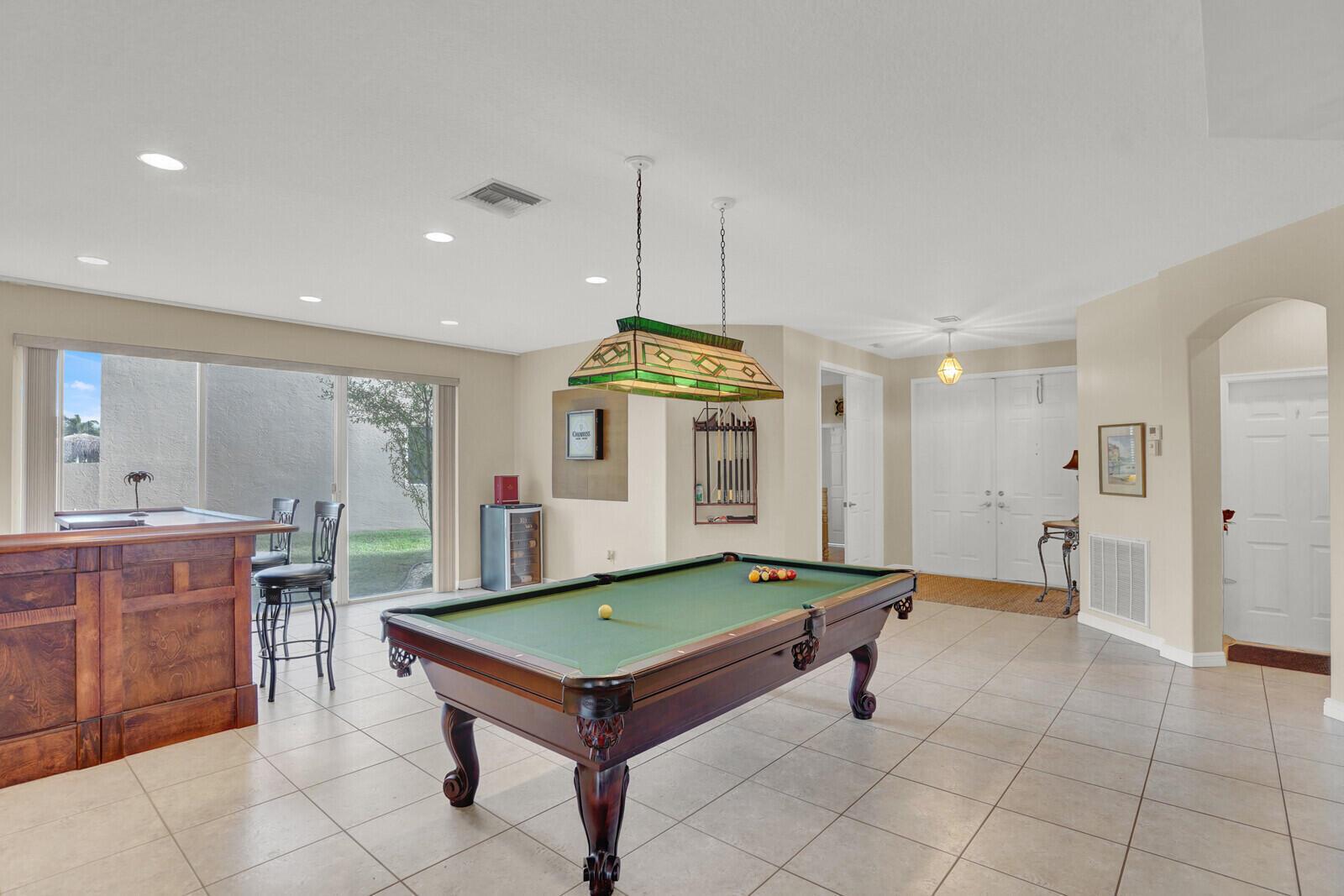 A game room features a pool table, a wooden bar, and tile flooring — 7541 Downwinds Lane, Lake Worth FL 33467, LAKE WORTH, FL
