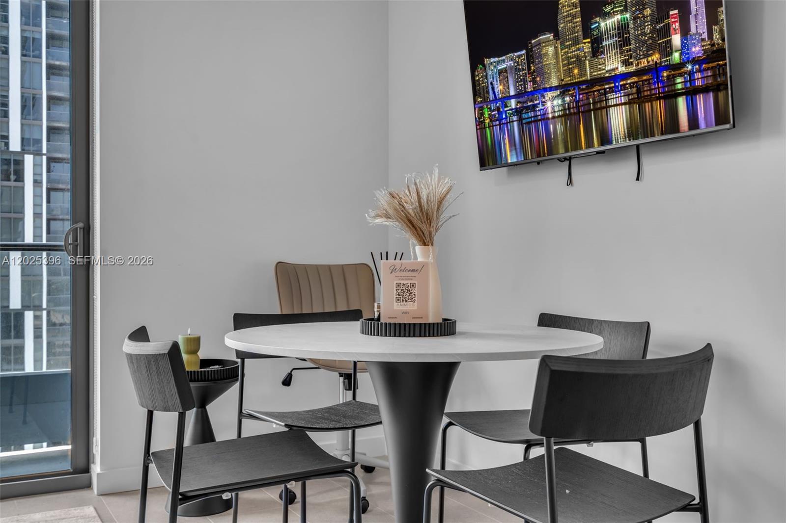 A dining area features a round white table, four chairs, and a wall-mounted television — 121 NE 5th St # 2107, Miami FL 33132, MIAMI, FL