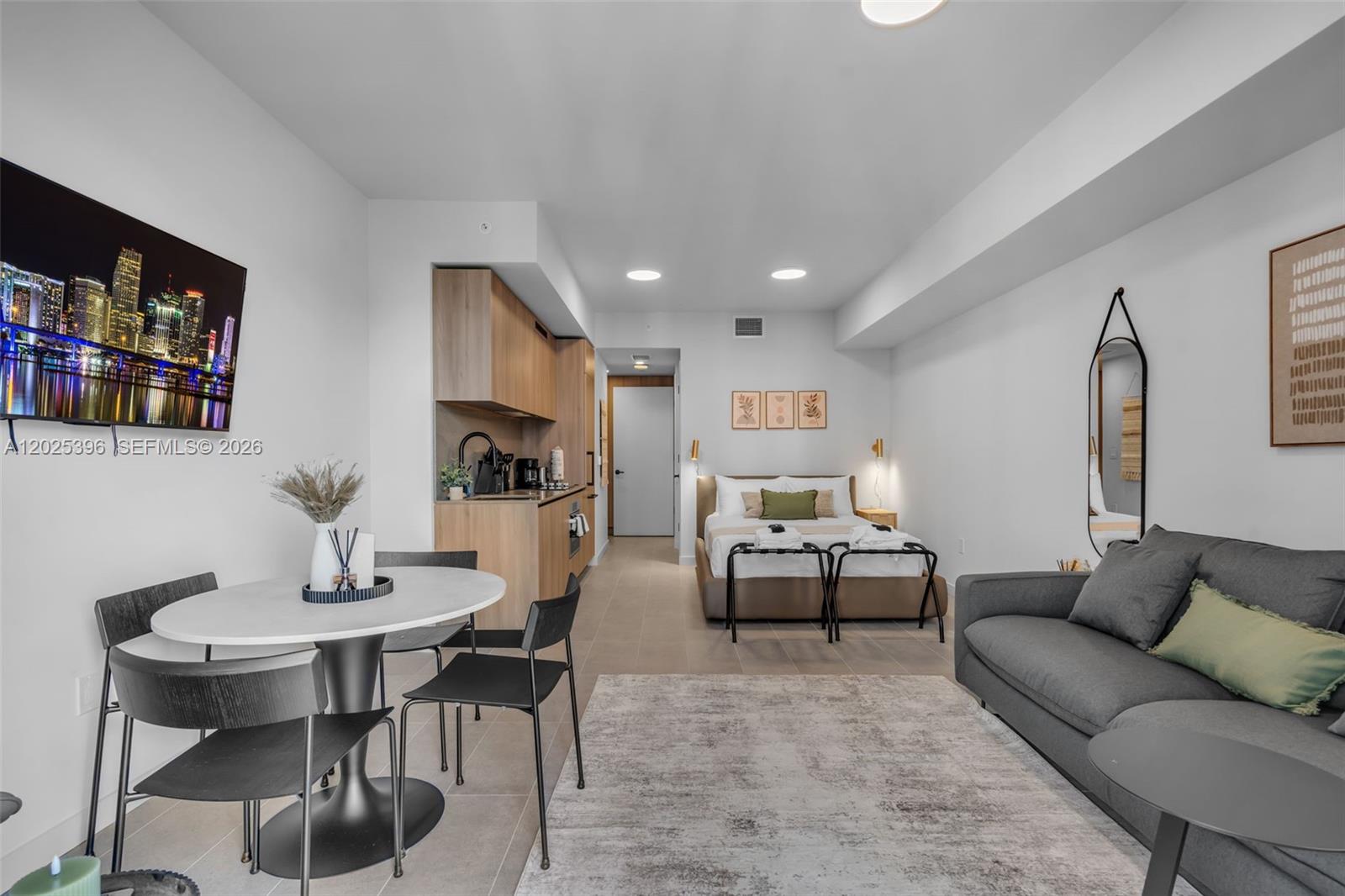 A studio apartment features a kitchenette, dining area, bed, and sofa on a tiled floor — 121 NE 5th St # 2107, Miami FL 33132, MIAMI, FL