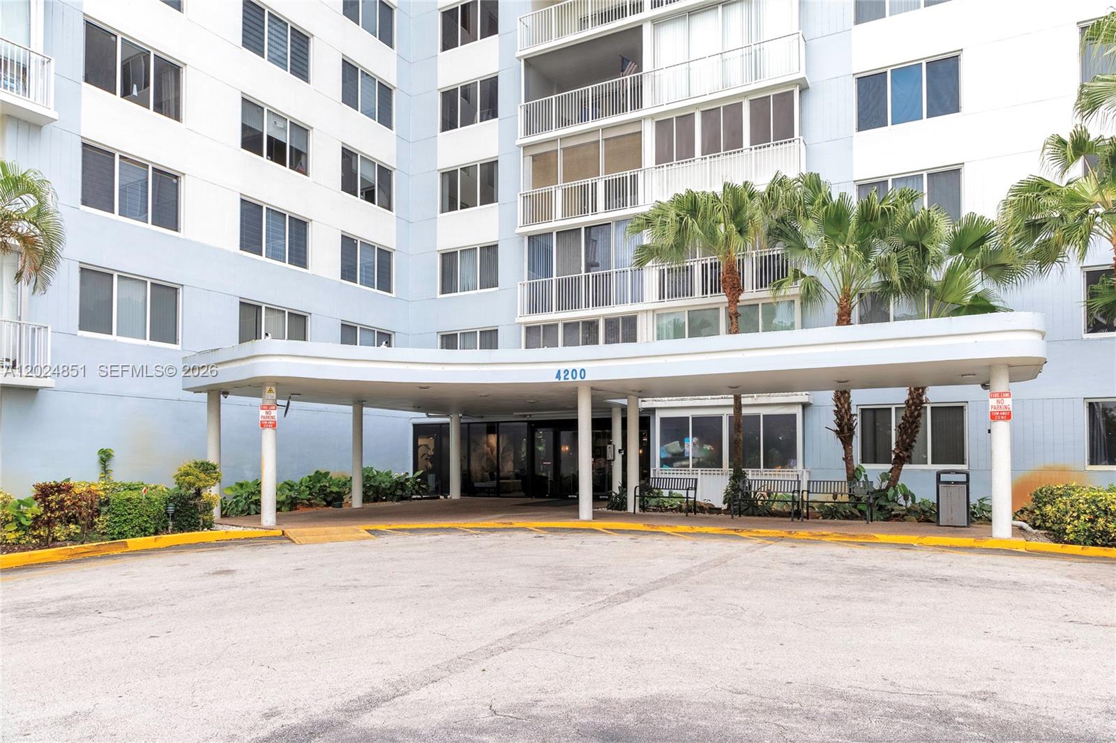 The exterior of a multi-story apartment building features a covered entrance with a circular driveway — 4200 Hillcrest Dr # 504, Hollywood FL 33021, HOLLYWOOD, FL