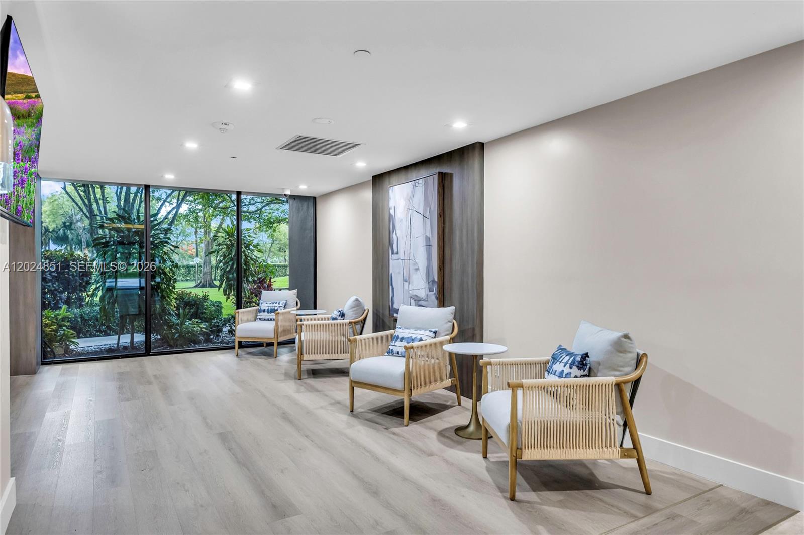 A modern lounge area features four light-colored armchairs, a small side table, and floor-to-ceiling windows — 4200 Hillcrest Dr # 504, Hollywood FL 33021, HOLLYWOOD, FL