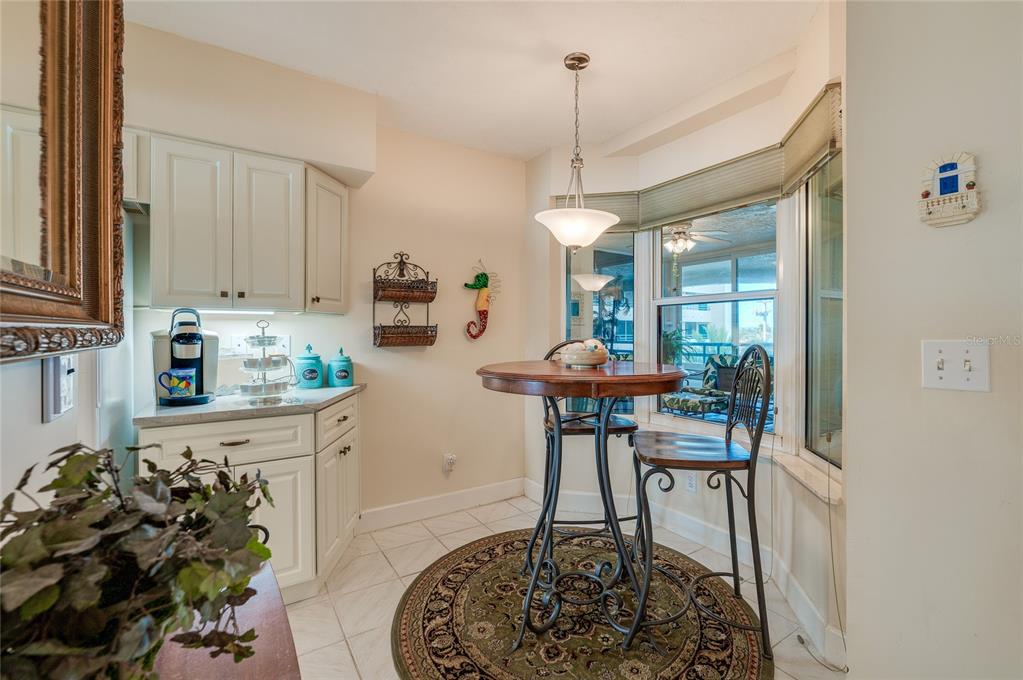 A breakfast nook with white cabinets, a round wooden table, and a window view — 4555 S ATLANTIC AVENUE UNIT 4304, PORT ORANGE, FL