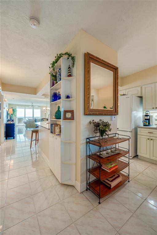 A kitchen and dining area features tile floors, a corner bookshelf, and a wooden shelf — 4555 S ATLANTIC AVENUE UNIT 4304, PORT ORANGE, FL