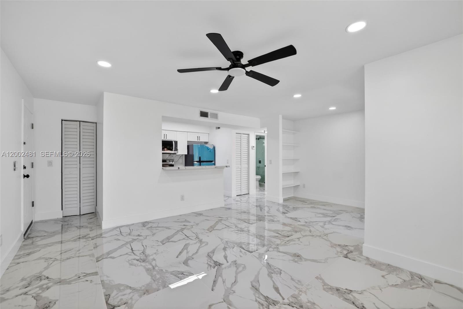 A bright, open-concept living area features white walls, marble-patterned tile flooring, and a ceiling fan — 1227 SW 46th Ave # 314, Pompano Beach FL 33069, POMPANO BEACH, FL