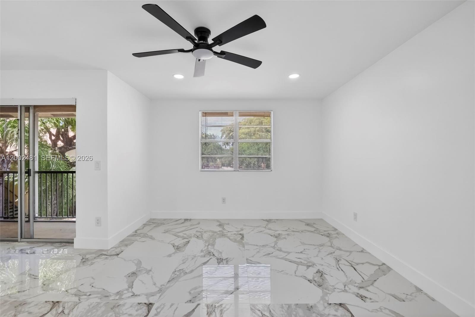 An empty room features white walls, marble-patterned tile flooring, a ceiling fan, and a sliding glass door — 1227 SW 46th Ave # 314, Pompano Beach FL 33069, POMPANO BEACH, FL