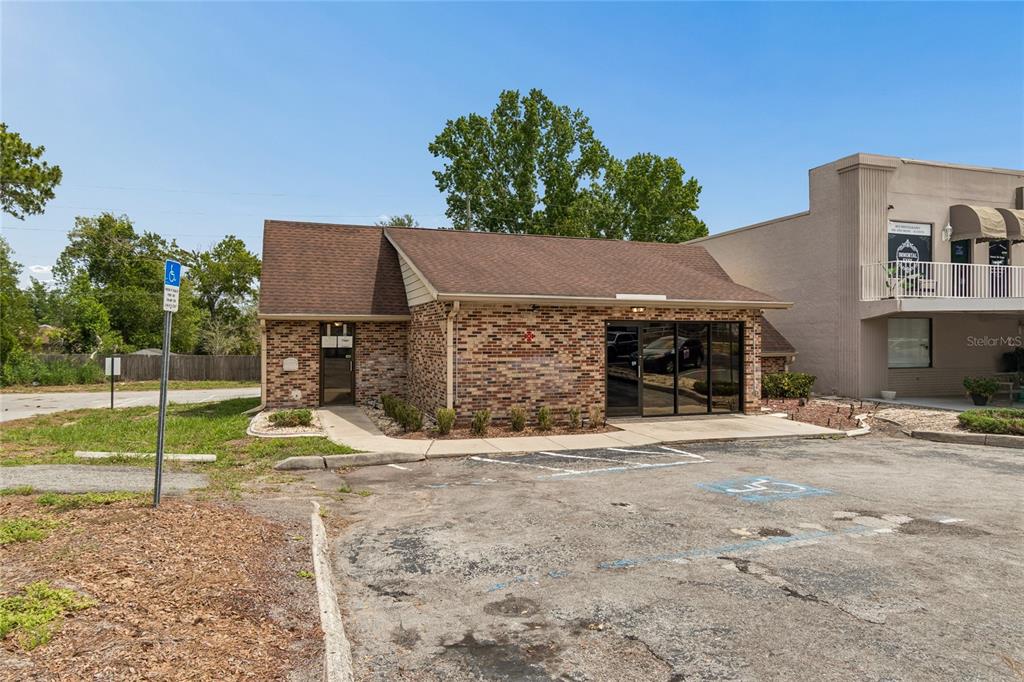 A brick commercial building with a brown shingled roof and a paved parking lot — 11151 SPRING HILL DRIVE, SPRING HILL, FL