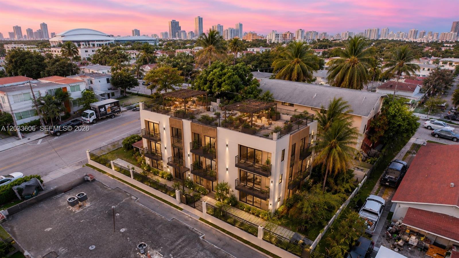 An aerial view shows a modern three-story apartment building with a rooftop terrace at sunset — 1267 NW 3rd St, Miami FL 33125, MIAMI, FL
