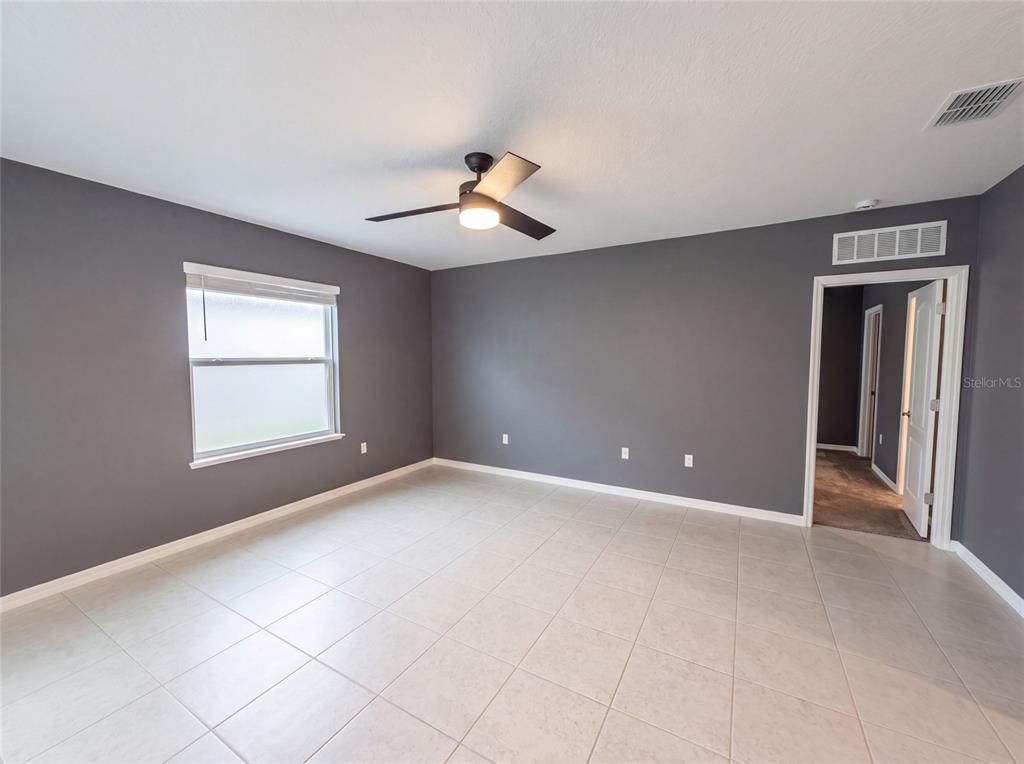A bedroom with gray walls, light tile flooring, and a ceiling fan — 1443 GENERAL CUSTER AVENUE, DAYTONA BEACH, FL