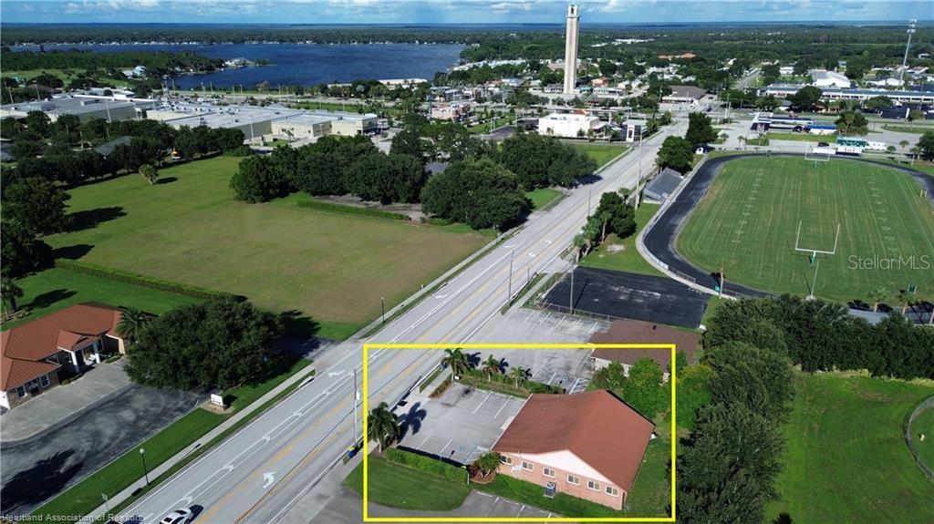 An aerial view shows a commercial building with a parking lot next to a road — 308 DAL HALL BOULEVARD, LAKE PLACID, FL