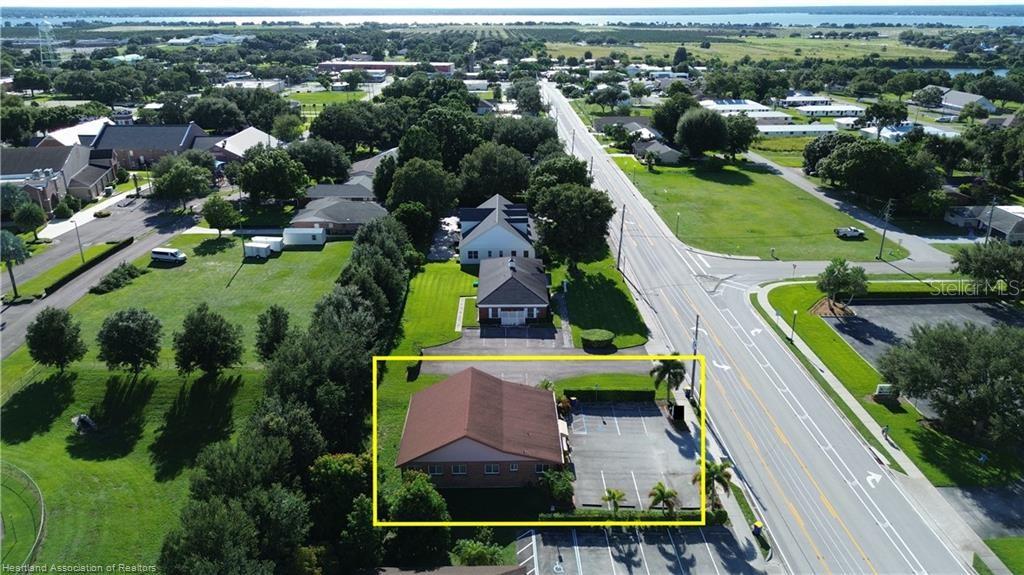 An aerial view shows a commercial building with a parking lot next to a road — 308 DAL HALL BOULEVARD, LAKE PLACID, FL