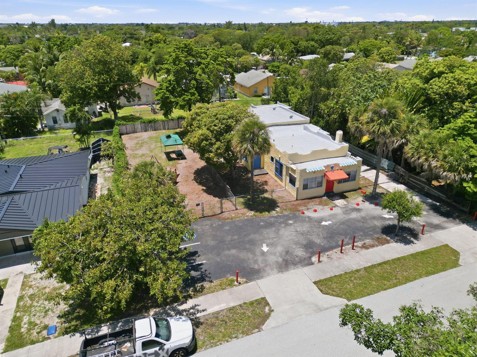 An aerial view shows a yellow commercial building with a parking lot and fenced yard — 216 SW 2nd Avenue, Delray Beach FL 33444, DELRAY BEACH, FL
