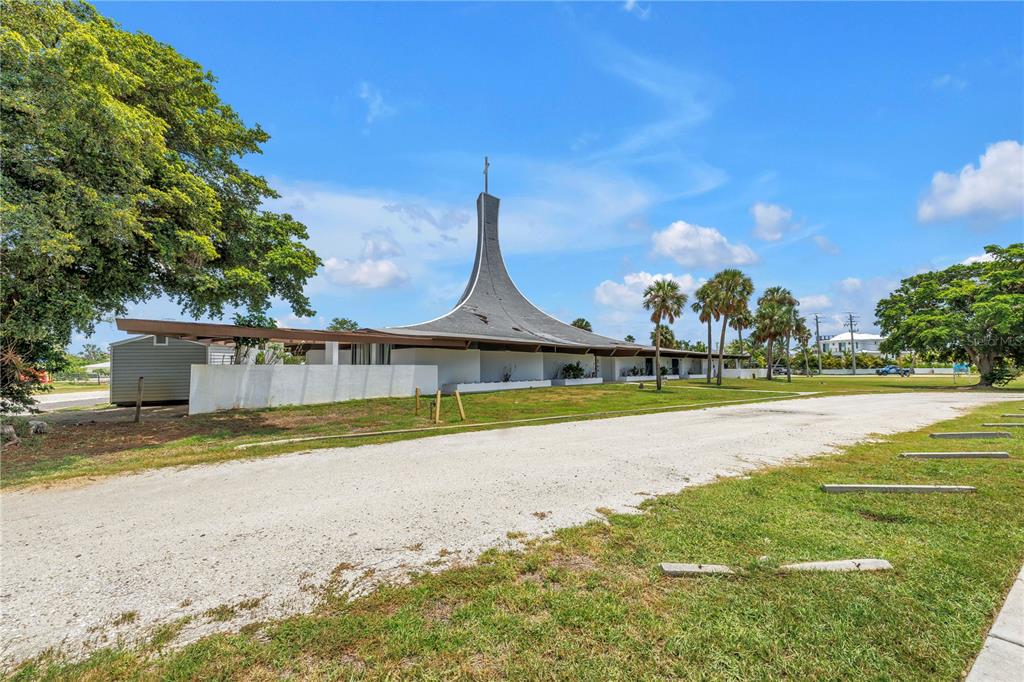 A mid-century modern church building with a distinctive curved roof and a cross on top — 6608 MARINA DRIVE, HOLMES BEACH, FL