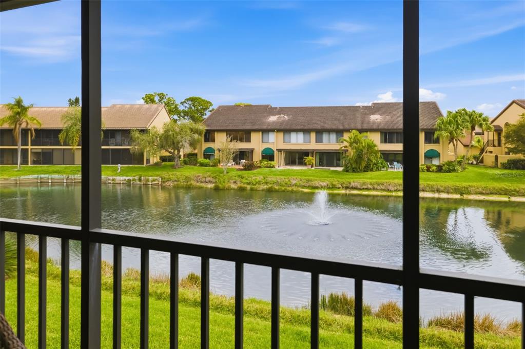 A view of a pond with a fountain from a screened-in porch — 5543 ASHTON WAY UNIT 5543, SARASOTA, FL