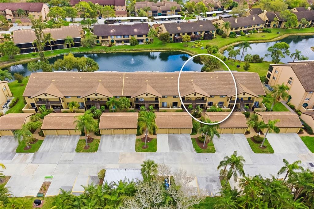 An aerial view shows a multi-story residential building with a tiled roof and garages — 5543 ASHTON WAY UNIT 5543, SARASOTA, FL
