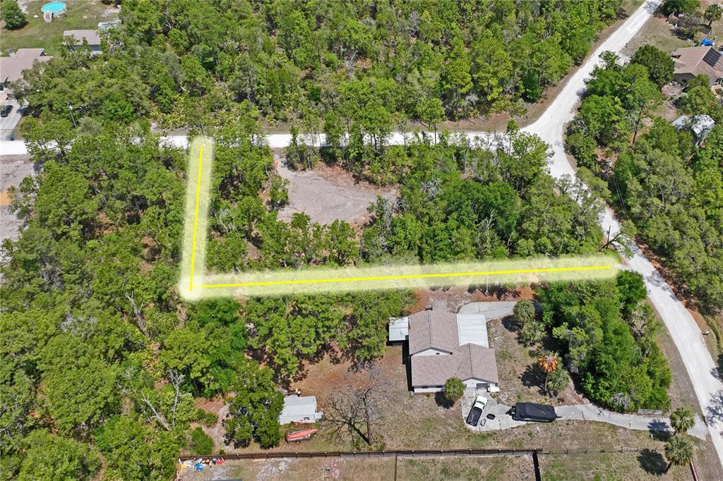 An aerial view shows a wooded residential lot with a highlighted boundary line — 0 YELLOWSTONE AVENUE, WEEKI WACHEE, FL