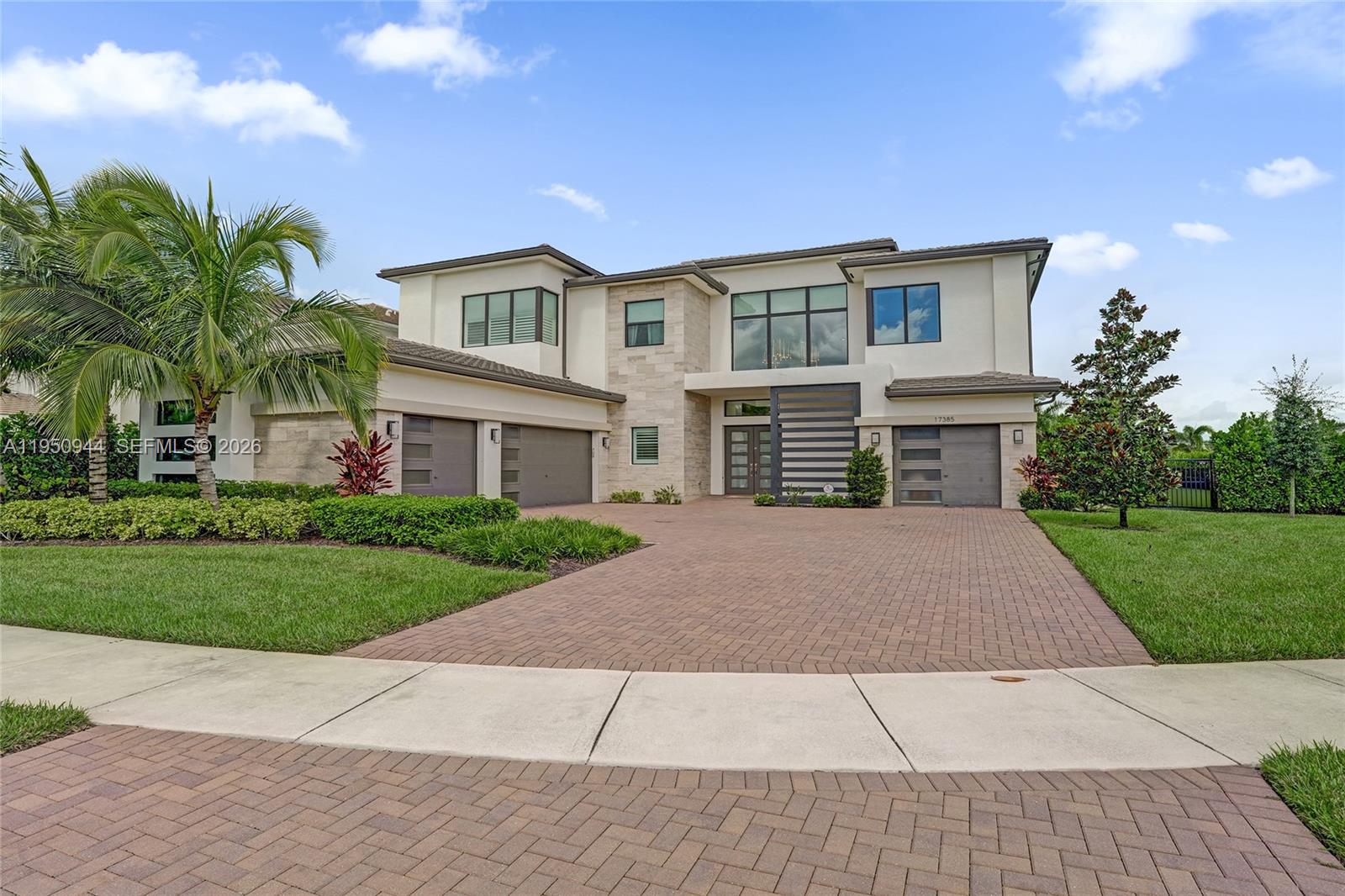 A two-story modern house with a three-car garage and a paved driveway — 17385 Ponte Chiasso Dr, Boca Raton FL 33496, BOCA RATON, FL