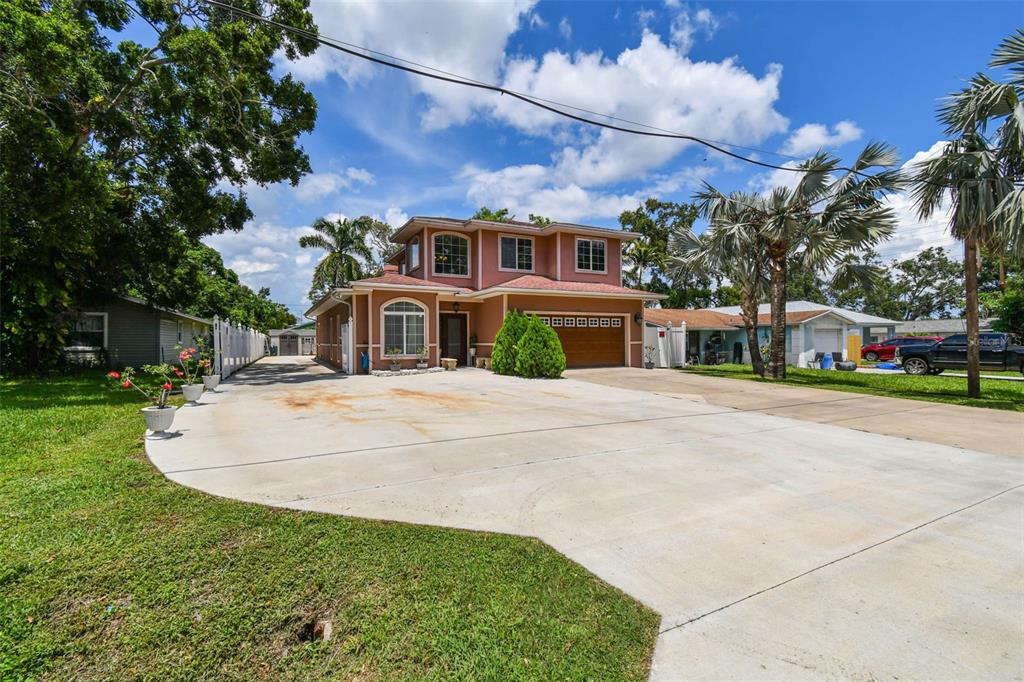 A two-story, peach-colored house with a large concrete driveway and a two-car garage — 3225 71ST AVENUE N, ST PETERSBURG, FL