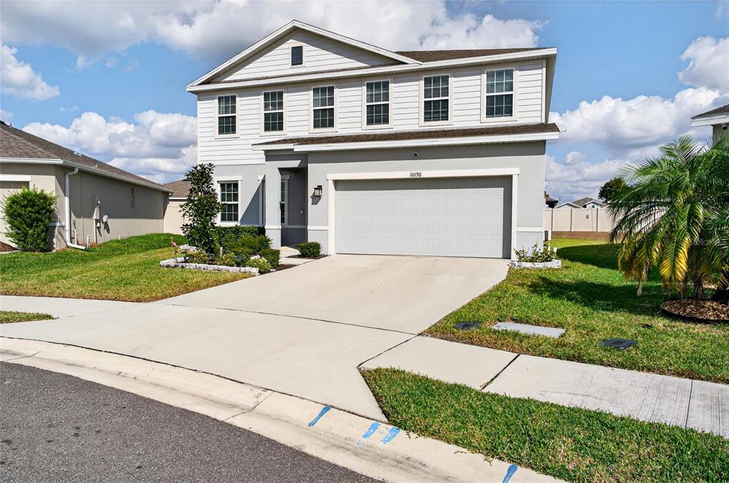 A two-story suburban house with a gray garage, white siding, and a concrete driveway — 10196 AGAVE COURT, LAND O LAKES, FL
