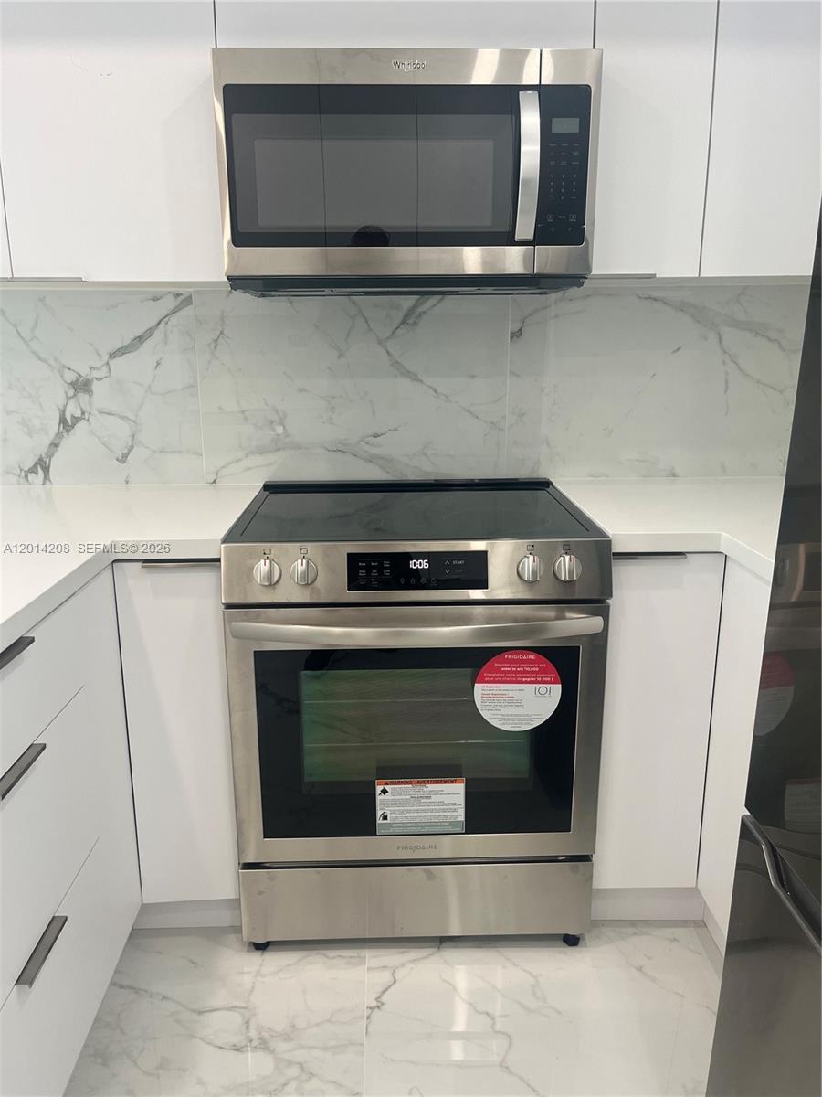 A stainless steel Frigidaire range and Whirlpool microwave are set against white cabinets and backsplash — 3505 S Ocean Dr # 210, Hollywood FL 33019, HOLLYWOOD, FL
