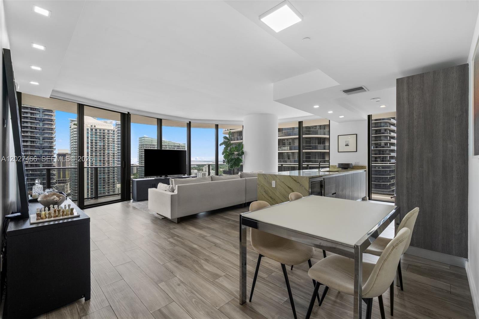 A modern open-concept living and dining area features floor-to-ceiling windows with city views — 801 S Miami Ave # 2901, Miami FL 33130, MIAMI, FL