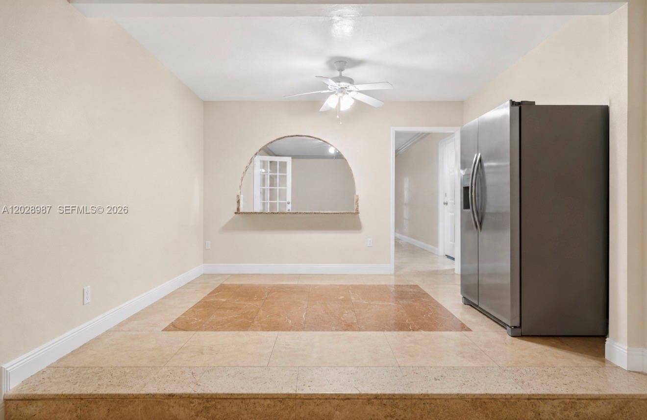This room features a raised tile floor, a stainless steel refrigerator, and an arched cutout — 3315 NW 11th Ave, Miami FL 33127, MIAMI, FL