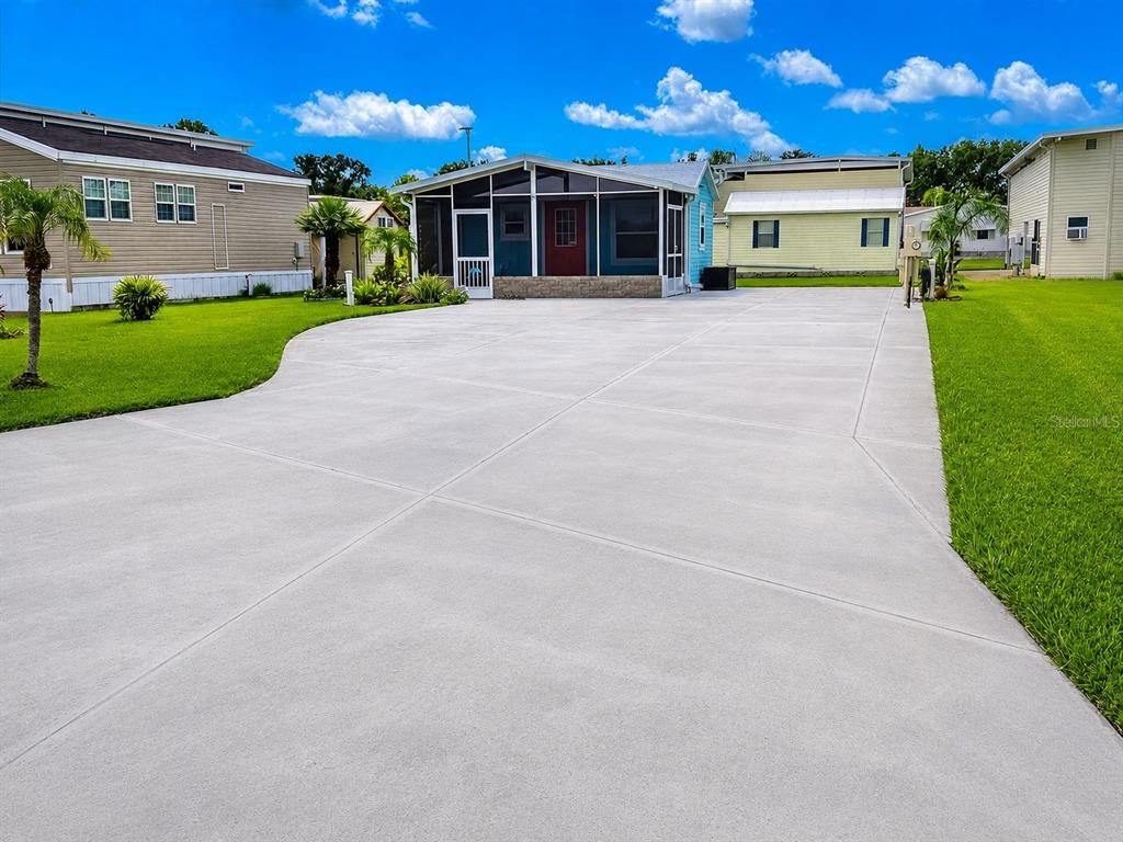 A single-story house with a screened front porch and a large concrete driveway — 5245 ISLAND VIEW CIRCLE N, POLK CITY, FL