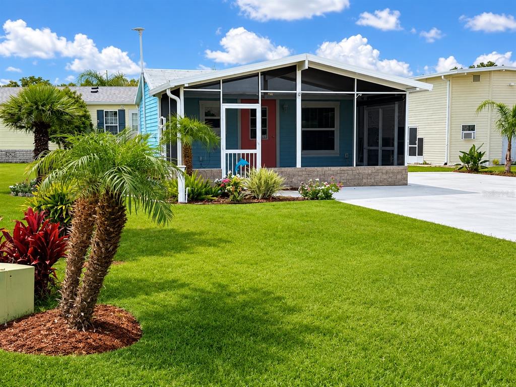 A blue manufactured home features a screened-in front porch and a manicured lawn — 5245 ISLAND VIEW CIRCLE N, POLK CITY, FL
